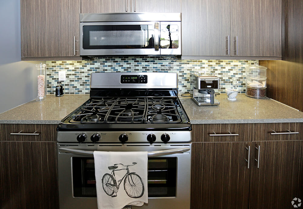 kitchen counter stainless steel oven, built in microrwave and backsplash